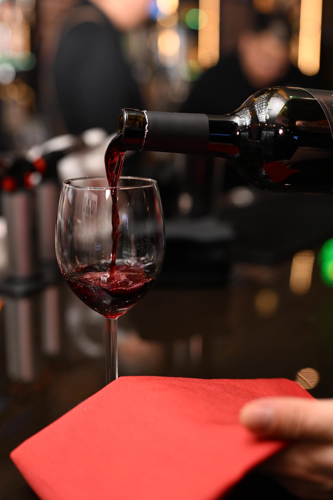 Red wine being poured into a glass at the Lisle Trattoria